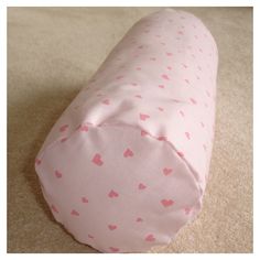 a pink baby sleeping bag with hearts all over it's side on the floor