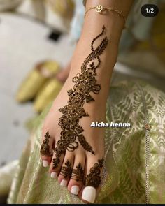 a woman's foot with henna tattoos on it