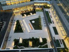 an aerial view of a building with lots of plants on the ground and lights in the windows