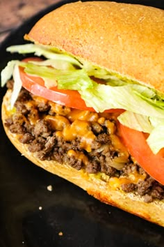 a close up of a sandwich on a plate with lettuce, tomato and cheese