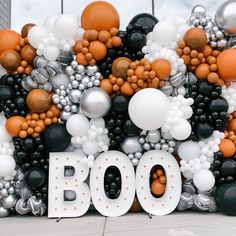 a large balloon display with the word boo spelled out in white, black, and orange balloons