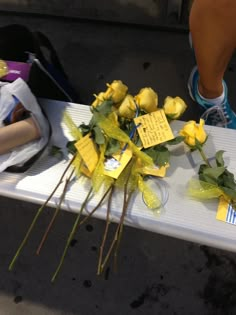 flowers are placed on a table with notes attached to the top and bottom of it