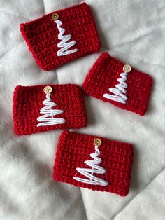 three red crocheted christmas ornaments on a white sheet