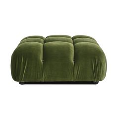 a green velvet footstool sitting on top of a white floor