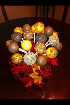 a vase filled with chocolate candies on top of a table next to autumn leaves