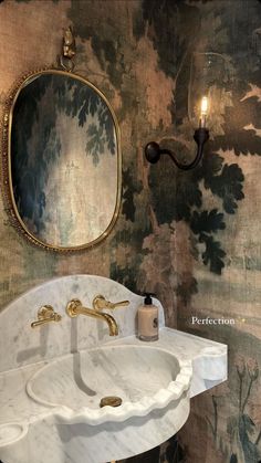 a white sink sitting under a bathroom mirror next to a wall mounted faucet