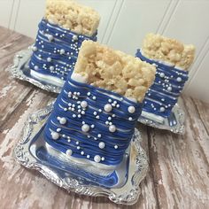 two blue and white cakes sitting on top of a silver tray next to each other