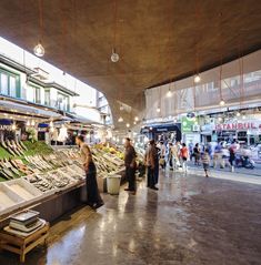 people are shopping in an open market with lots of fish