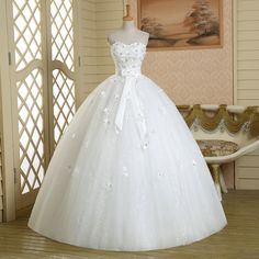 a white wedding dress on display in a room