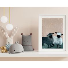 two stuffed animals are sitting on a shelf next to a framed photo and an animal toy