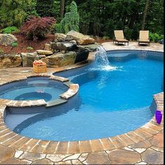 a swimming pool surrounded by stone steps and landscaping