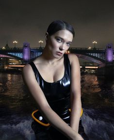 a woman in a wet suit holding a yellow and black life preserver while standing next to the water