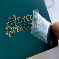 a person holding up a plastic sticker with the words velvet apparition on it