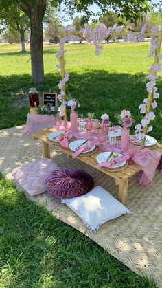 a picnic table set up with pink and white flowers