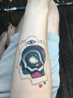 a man with a tattoo on his arm has an eye in the shape of a woman's head