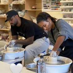 two people working on pottery in a shop