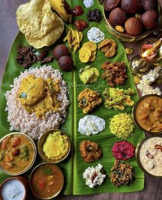 an assortment of different foods on a banana leaf