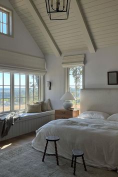 a large bed sitting in a bedroom next to two windows