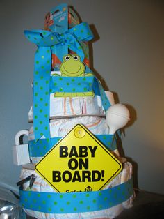 a baby on board diaper cake sitting on top of a table next to a sign