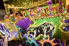 the float is decorated with colorful decorations and people holding up their hands in the air