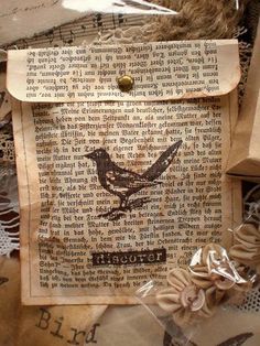 an old book with a bird on it is surrounded by laces and other items