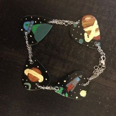 this is a necklace made out of guitar pickers and other items on a table