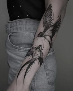 a person with a bird tattoo on their arm