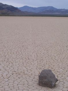 a rock sitting in the middle of a desert