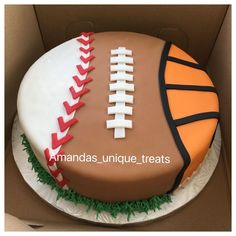 a birthday cake decorated with a football and soccer ball on the side in a box