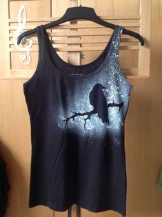 a women's tank top with a bird painted on it