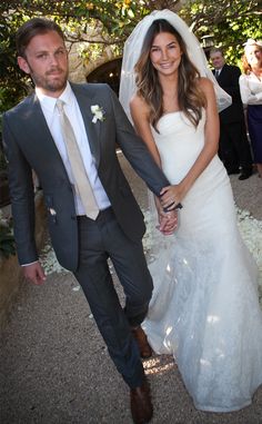 a bride and groom walking down the aisle