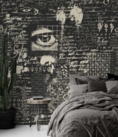 a bedroom with black and white wallpaper that has writing all over it, including an eye