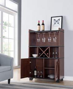 a wooden cabinet with wine glasses and bottles on it in front of a gray couch