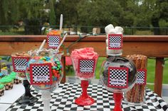 a table topped with desserts and candies on top of a checkered table cloth