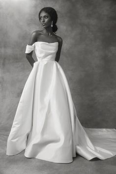 a woman in a white wedding dress posing for a photo with her hands on her hips