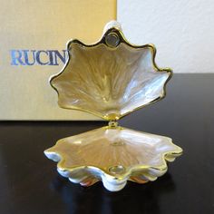 a glass dish sitting on top of a table next to a box with the word rucin written in it