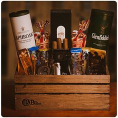 a wooden crate filled with lots of different types of liquors and snacks in it