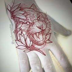 a hand that has a tattoo on it with a tiger's head in the middle