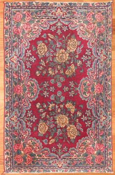 a red rug with floral designs on it