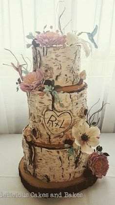 a three tiered cake decorated with flowers and leaves