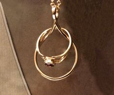 a gold necklace with two rings hanging from it