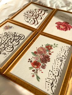 three framed pictures with flowers and calligraphy in them on a white sheeted surface