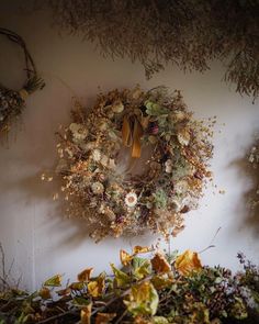 a wreath hanging on the wall with dried flowers