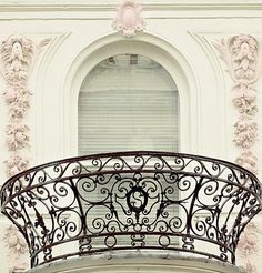 an ornate balcony with wrought iron balconies and shutters, in black and white