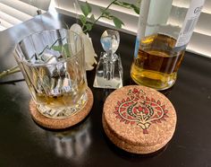 there is a glass cup next to a cork coaster and bottle opener on the table