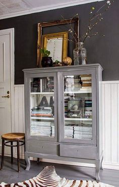 a room with a zebra print rug and gray china cabinet