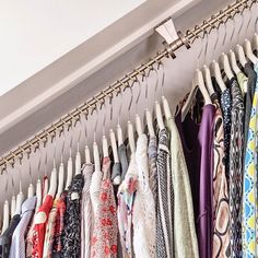 an organized closet with clothes hanging on hooks