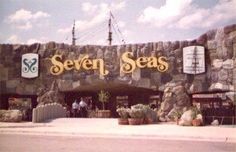 the entrance to seven seas with people standing in front and looking at them from outside