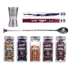 an assortment of spices and seasonings in glass jars with spoons on white background