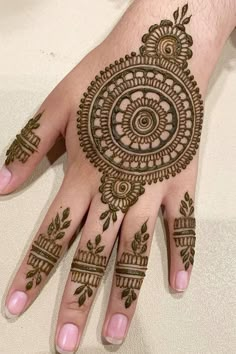 a henna tattoo on the palm of someone's hand, with an intricate design